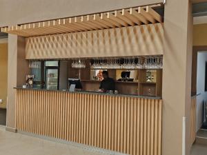 a man standing at a bar in a restaurant at TACOA Boutique Hotel in Westonaria