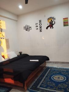 a bedroom with a bed with black sheets and a rug at peak&valley homestay in Dharmsāla