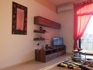 a living room with a tv and a mirror at Marjanapartment in Marsaskala