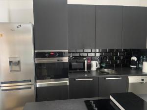 a kitchen with a stainless steel refrigerator and a sink at Pokoje Zwycięstwa in Gliwice