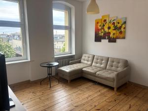 a living room with a couch and two windows at Pokoje Zwycięstwa in Gliwice