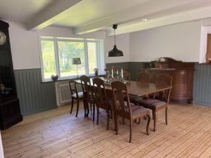 a dining room with a wooden table and chairs at Starby bondgård in Ängelholm