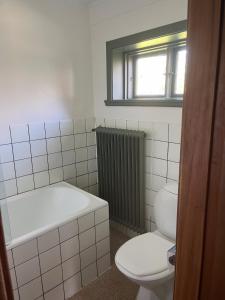 a bathroom with a tub and a toilet and a window at Starby bondgård in Ängelholm +27 photos