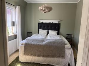 a bedroom with a large bed with a black headboard at Starby bondgård in Ängelholm