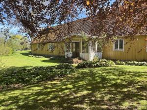a yellow house with a grass yard at Starby bondgård in Ängelholm