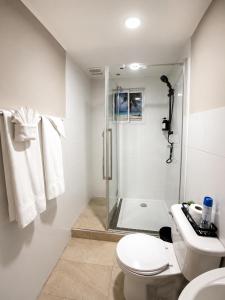 a white bathroom with a shower and a toilet at Valfe Apartments in Palm-Eagle Beach +11 photos