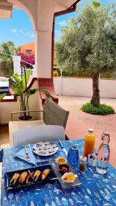 a table with a blue table cloth with food on it at Sicilia Meraviglia B&B in Fontane Bianche