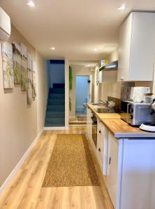 a kitchen with white cabinets and a blue staircase at L'Échappée iodée à "La Cahute" - Rénovée, Calme & Proche Mer in Ambleteuse