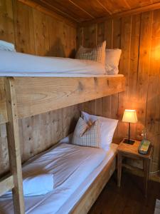 two bunk beds in a wooden room with a lamp at Kyrkjestølen B&B in Tyinkrysset