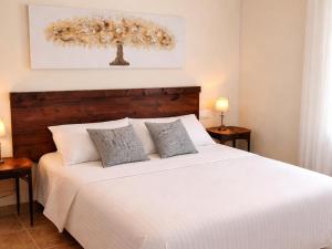 a bedroom with a white bed with two pillows at Chalet in Rivero de Posadas with Pool in Rivero de Posadas