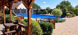 a backyard with a swimming pool and a table and benches at Apartamenty Maciejowy Sad in Sady Dolne