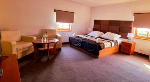 a bedroom with a bed and a couch and a table at Apartamenty Maciejowy Sad in Sady Dolne