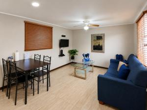 a living room with a blue couch and a table at Valfe Apartments in Palm-Eagle Beach