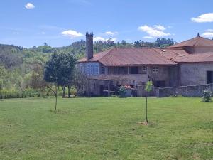 a large house with a field in front of it at Casa da Torreira Naturaleza y descanso in Galegos