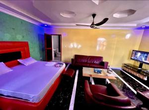 a bedroom with a bed and a couch and a table at RÉSIDENCE MAME DIARRA kl in Kaolack
