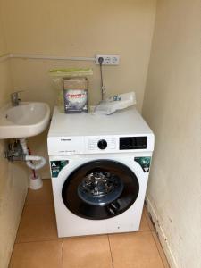 a washing machine in a bathroom next to a sink at Casa da Maria in Prazeres