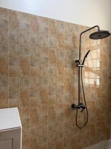 a shower in a bathroom with a tiled wall at Bubuli country club in Lyamutundwe +30 photos