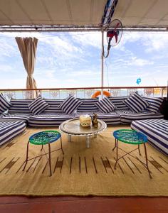 a living room on a cruise ship with a table and two chairs at Youssef Nile Boat in Luxor