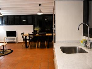 a kitchen with a sink and a table with chairs at Sésamo Apartamento in Hervás