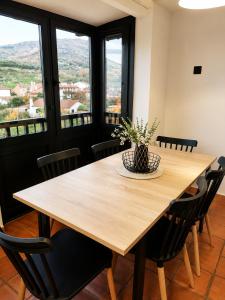 a wooden table with chairs and a vase of flowers on it at Sésamo Apartamento in Hervás