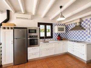 a kitchen with white appliances and blue and white tiles at Sésamo Apartamento in Hervás +19 photos