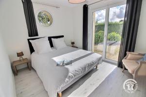 a bedroom with a bed and a large window at Mathilde in Lannion