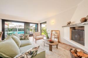 a living room with a couch and a fireplace at Сasa do Cedro in Colares
