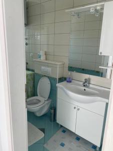 a bathroom with a toilet and a sink at Beachside 2-Bed Bliss! in Blace