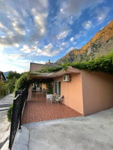 a house with a brick patio with a fence at Apartments Marash in Kotor