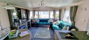 a living room with a couch and a table at Trecco Bay Cwtch Caravan in Newton