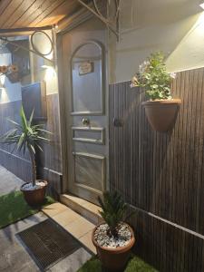 a front door with two potted plants on a fence at Corte26 in Nocera Inferiore