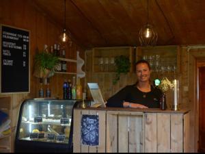 a woman standing at a bar in a restaurant at Kyrkjestølen B&B in Tyinkrysset