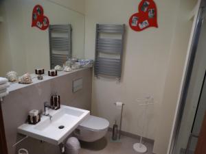 a bathroom with a toilet and a sink and a mirror at Aldi Apartments Porta Mare in Dziwnówek