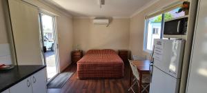 a small kitchen with a table and a refrigerator at Rivergums Caravan Park in Goondiwindi