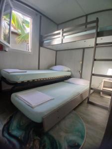 a bedroom with two bunk beds and a ladder at Au Paradis de Peggy - Bungalow 5 pers - Village de la Pointe Faula in Le Vauclin