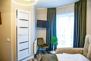 a bedroom with a bed and a chair and a window at Готель-Ресторан Соната in Sambir +52 photos