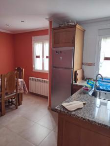 a kitchen with a stainless steel refrigerator and a sink at Apartamento Duplex con jardín A Casiña de Divina in Lago +43 photos