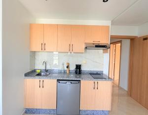 a kitchen with wooden cabinets and a stainless steel dishwasher at Stay with US in Agadir