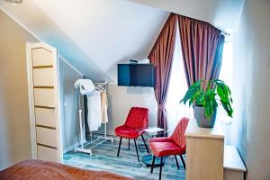 a bedroom with two red chairs and a window at Готель-Ресторан Соната in Sambir