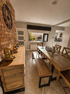 a dining room with a table and a brick wall at The Hillcrest, Luxury Accommodation in Castleblayney Town in Castleblayney