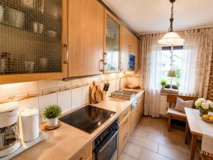 a kitchen with wooden cabinets and a counter top at Erholungs-Apartment mit Balkon nahe Therme & Klinik in Bad Lippspringe