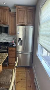 a kitchen with a stainless steel refrigerator and wooden cabinets at Maggie S Place in Salem