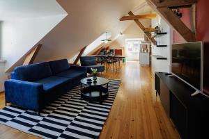 a living room with a blue couch and a table at Historic Haven in Riga