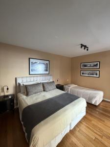 a bedroom with two beds and two pictures on the wall at Maitre Hotel Boutique in Buenos Aires