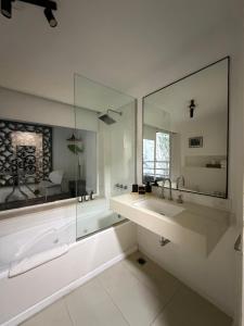 a white bathroom with a sink and a mirror at Maitre Hotel Boutique in Buenos Aires +59 photos