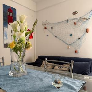 a vase with flowers on a table in a room at Nido sul Mare in Punta Braccetto