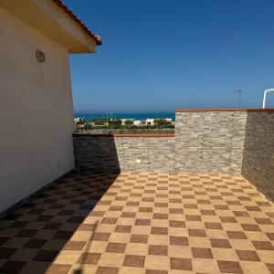 a room with a checkered floor and the ocean at Nido sul Mare in Punta Braccetto