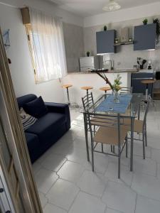a living room with a table and a blue couch at Nido sul Mare in Punta Braccetto