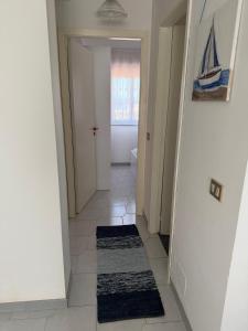 a hallway with a door and a rug on the floor at Nido sul Mare in Punta Braccetto