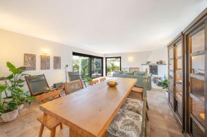 a living room with a wooden table and chairs at Сasa do Cedro in Colares